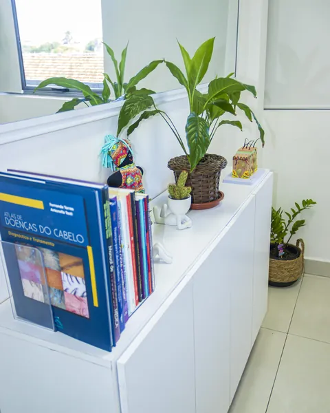 Estante com livros de tricologia e plantas