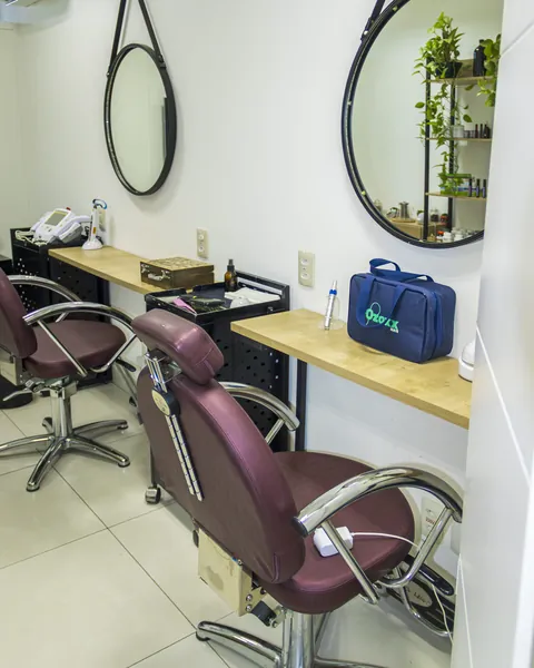 Sala de tratamento com cadeiras e espelhos